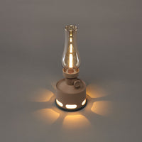 Braune LED-Sturmlampe mit Glaszylinder auf grauem Hintergrund, Vintage-Design, stimmungsvolle Beleuchtung.