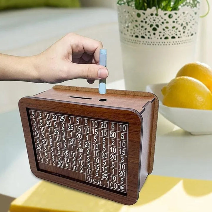 Hand steckt Münze in braune Holz-Spardose mit Zahlenraster, Tisch mit Zitronen im Hintergrund.