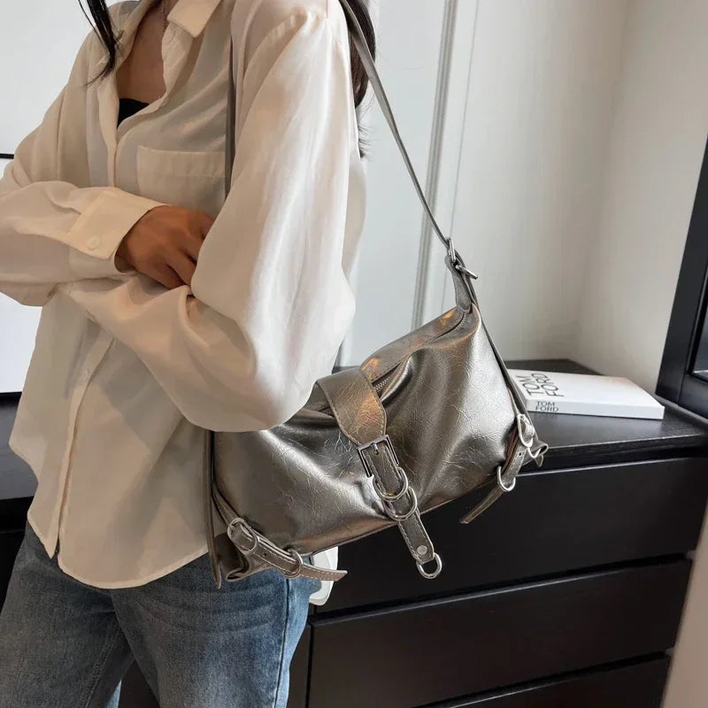Frau mit silberner Lederhandtasche, lässiger Stil, modisches Accessoire, Umhängetasche.
