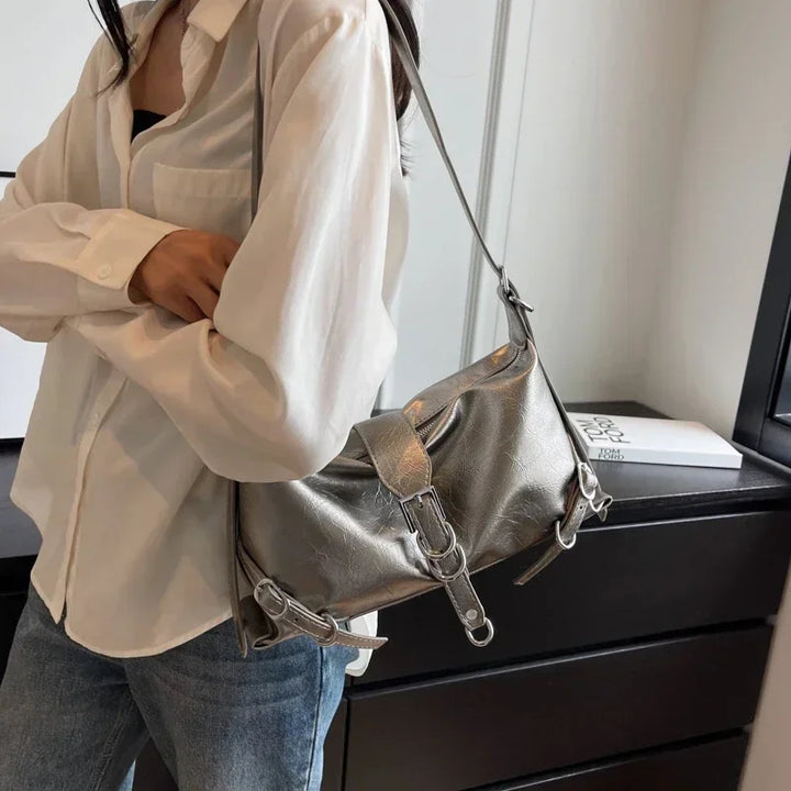 Frau mit silberner Lederhandtasche, lässiger Stil, modisches Accessoire, Umhängetasche.
