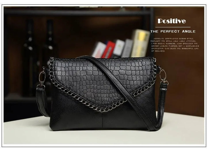 Schwarze Lederhandtasche mit Krokodilprägung und Kette, elegant und modisch.