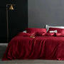 Rotes Satin-Bettwäsche-Set auf Doppelbett, modernes Schlafzimmer, goldene Stehlampe.
