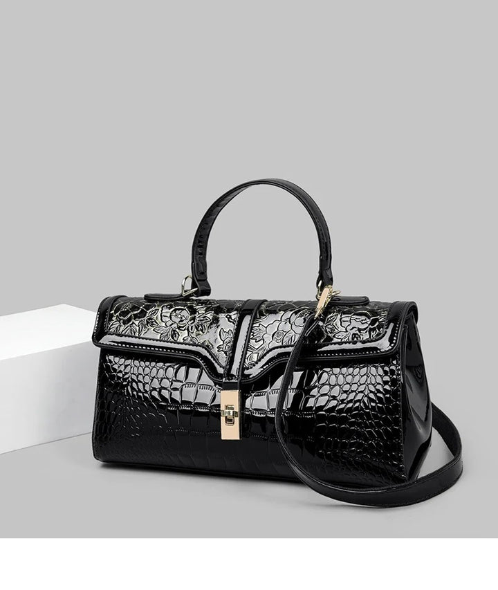 Schwarze Damenhandtasche aus Leder mit Krokodilprägung und Blumenmuster, elegant und stilvoll.