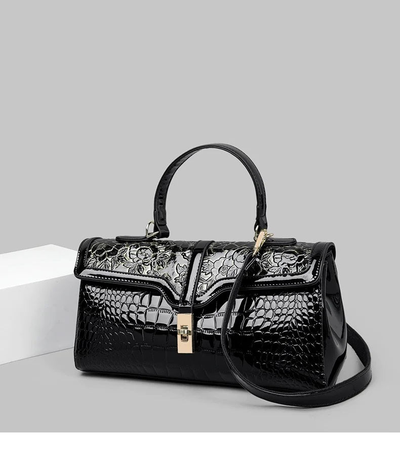 Schwarze Damenhandtasche aus Leder mit Krokodilprägung und Blumenmuster, elegant und stilvoll.