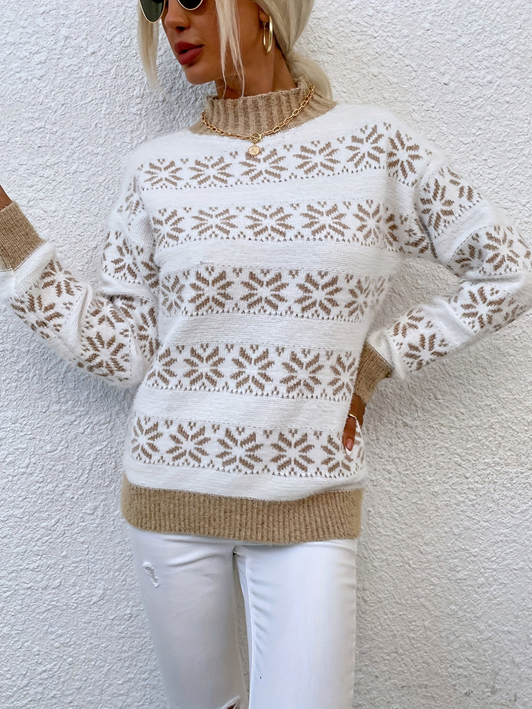 Frau in weißem Strickpullover mit Schneeflockenmuster, beige Details, modisch, elegant.