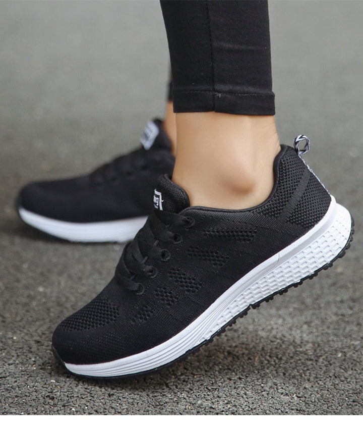 Schwarze Damen-Sneaker aus Mesh mit weißer Sohle, ideal für Laufen und Freizeit.