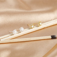 Goldene und silberne Perlenohrringe auf beigem Stoff, eleganter Schmuck, Nahaufnahme.