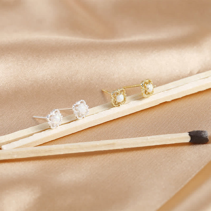 Goldene und silberne Perlenohrringe auf beigem Stoff, eleganter Schmuck, Nahaufnahme.