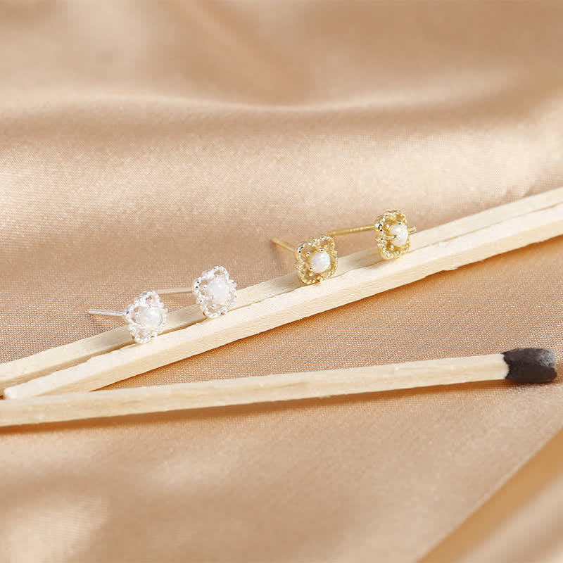 Goldene und silberne Perlenohrringe auf beigem Stoff, eleganter Schmuck, Nahaufnahme.