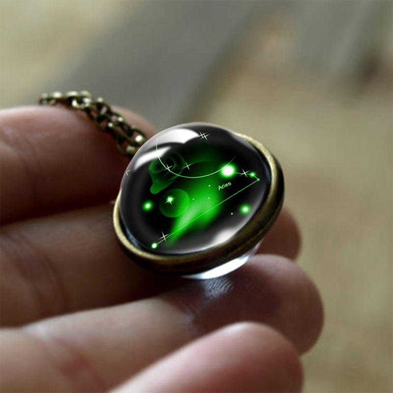 Glasanhänger mit grünem Galaxie-Design, bronzefarbenem Rand, handgehalten, Schmuckaccessoire.