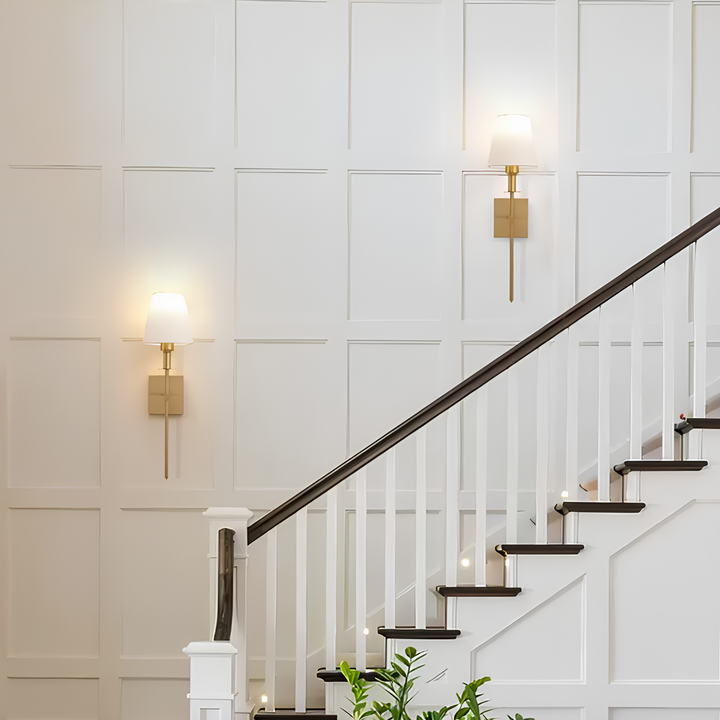 Weiße Treppe mit Holzgeländer, moderne Wandlampen, elegantes Interieur, minimalistische Wandverkleidung.