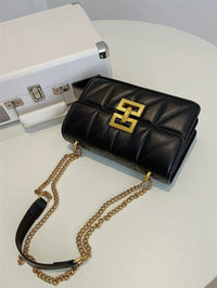 Schwarze Lederhandtasche mit goldener Kette und Logo, elegante Damenmode Accessoire.