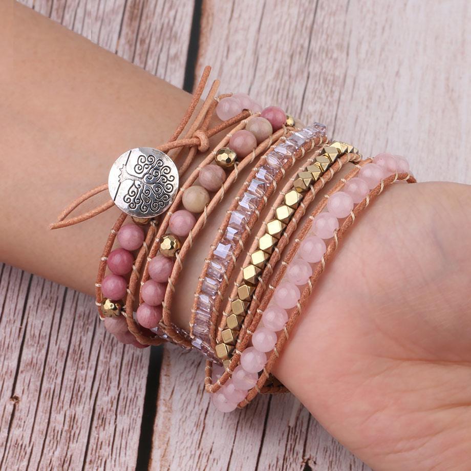 Armband-Set aus Leder und Perlen in Rosa und Gold auf Handgelenk, modisches Schmuckdesign.