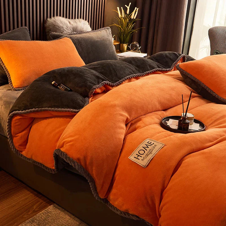 Orangefarbene Bettdecke aus Samt, gemütlich, mit grauen Akzenten, auf einem Bett im modernen Schlafzimmer.