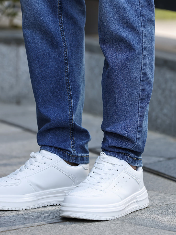 Weiße Sneaker aus Leder, getragen mit blauen Jeans, Straßenszene, modisch, bequem.