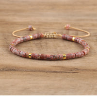 Rotes Steinarmband mit goldenen Akzenten, verstellbar, handgefertigt, Unisex-Schmuck.