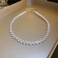 Perlenkette mit goldener Kette auf Tablett, eleganter Schmuck, klassisches Design, Damenaccessoire.