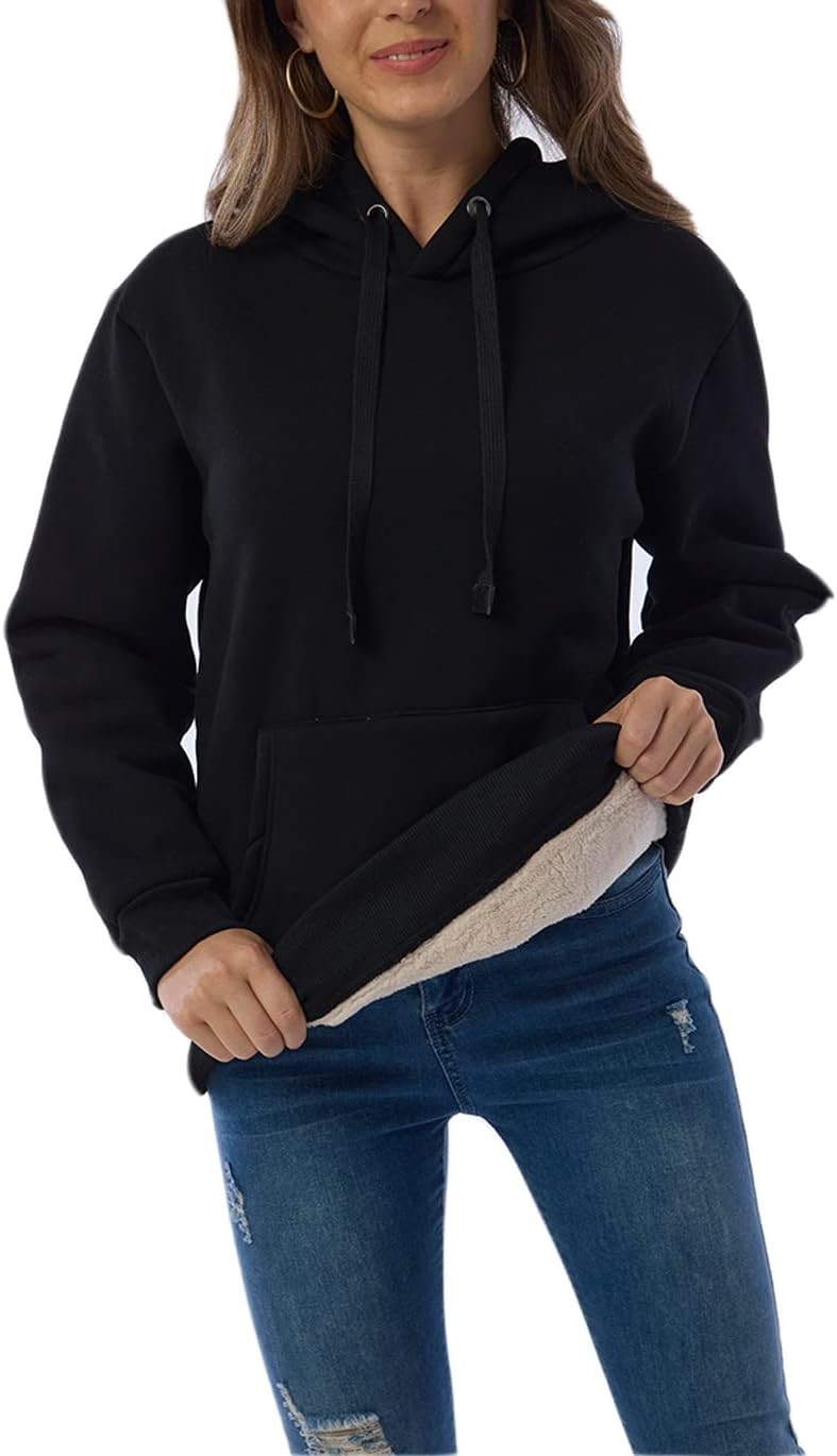 Frau in schwarzem Kapuzenpullover mit Fleece-Futter, blaue Jeans, lässige Mode.