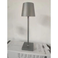 Graue LED-Tischlampe aus Metall, modern, energiesparend, auf weißer Verpackung.