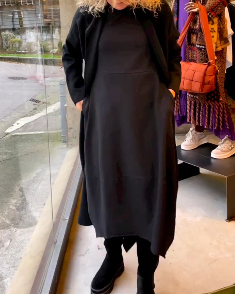 Frau in schwarzem Kleid und Mantel, schwarze Stiefel, Modegeschäft, Schaufenster, Herbstmode.
