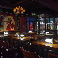 Gemütliches Restaurant mit Holztischen, modernen Tischlampen und stilvoller Wandkunst.