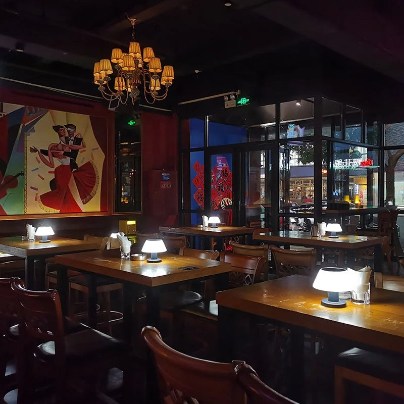 Gemütliches Restaurant mit Holztischen, modernen Tischlampen und stilvoller Wandkunst.