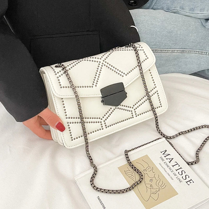 Weiße Umhängetasche mit Nieten, geometrisches Muster, Damenmode, elegantes Design.