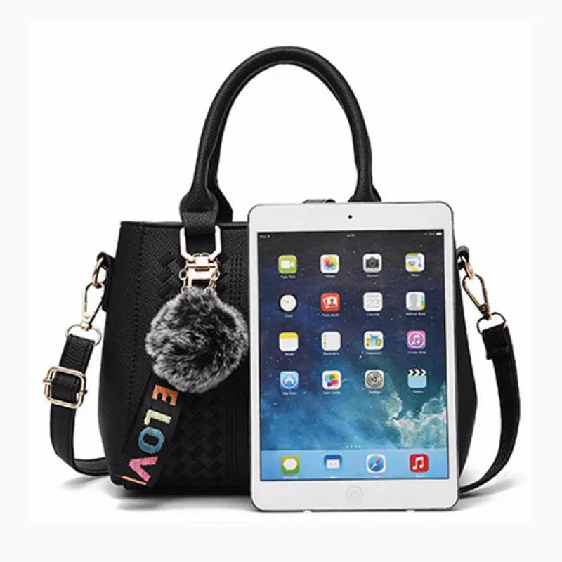 Schwarze Lederhandtasche mit iPad Mini, Pompon-Anhänger, modisch, Damenaccessoire.