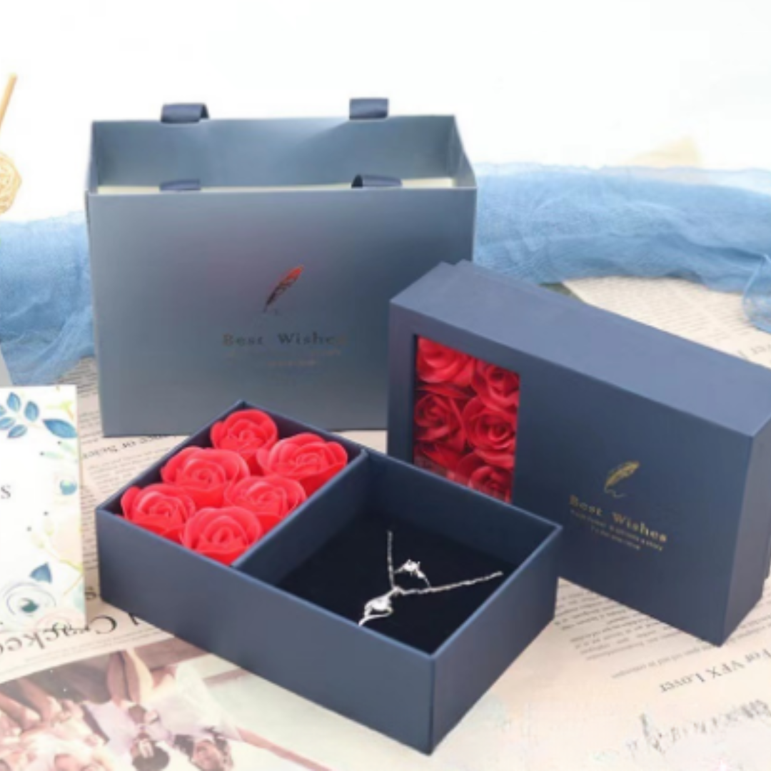 Blaue Geschenkbox mit roten Rosen und silberner Halskette, ideal für romantische Anlässe.