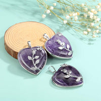 Herzförmiger Amethyst-Anhänger mit Silberverzierung auf Holzscheibe, Schmuckdesign.