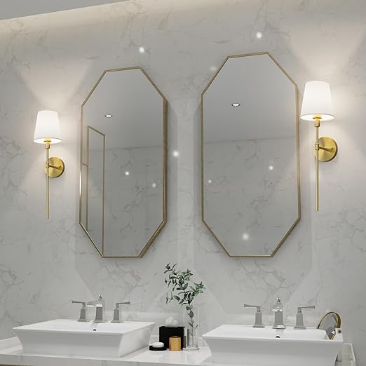 Zwei achteckige Spiegel mit goldenen Rahmen, Wandlampen, Doppelwaschbecken, modernes Badezimmerdesign.