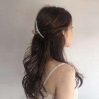 Frau mit Perlen-Haarspange, braunes Haar, elegantes Accessoire, modischer Haarschmuck.