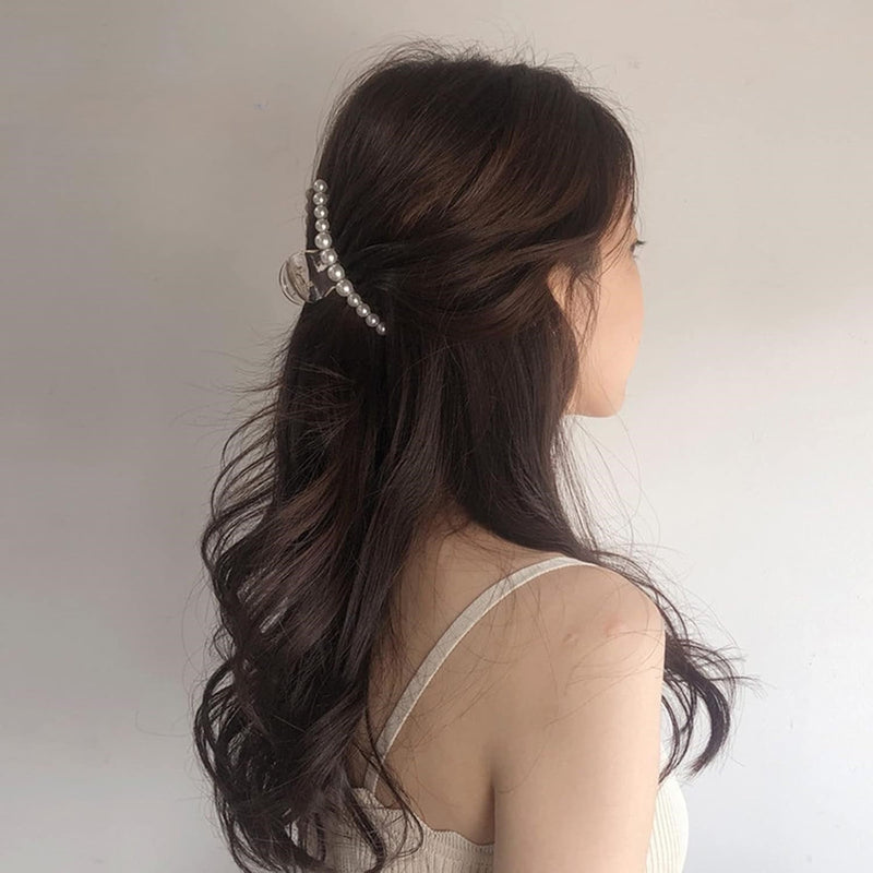 Frau mit Perlen-Haarspange, braunes Haar, elegantes Accessoire, modischer Haarschmuck.
