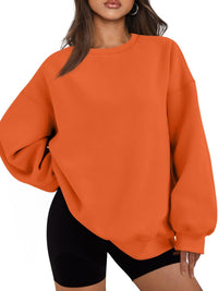 Frau in orangefarbenem Oversize-Pullover und schwarzen Shorts, modisch, lässig, bequem.
