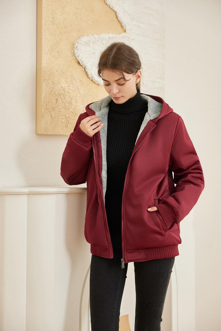 Frau in roter Winterjacke mit Kapuze und Fleece-Futter, schwarzer Rollkragenpullover, modern.
