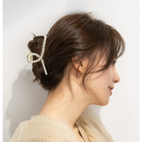 Frau mit Perlen-Haarklammer, eleganter Haarschmuck, Hochsteckfrisur, modisches Accessoire