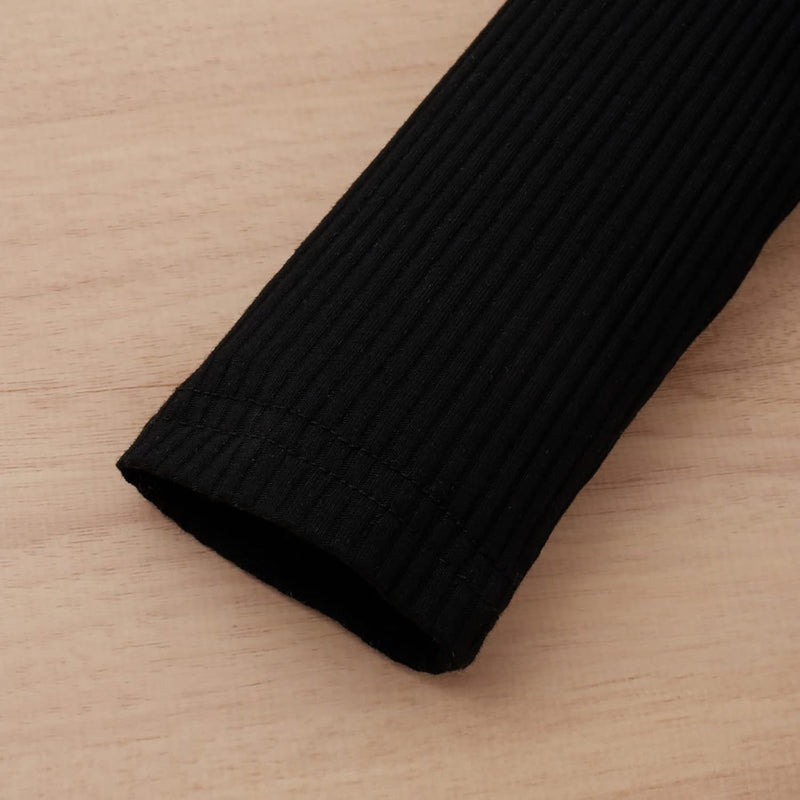 Schwarzer gerippter Ärmel aus Baumwolle auf Holzoberfläche, modisch, bequem, langlebig.