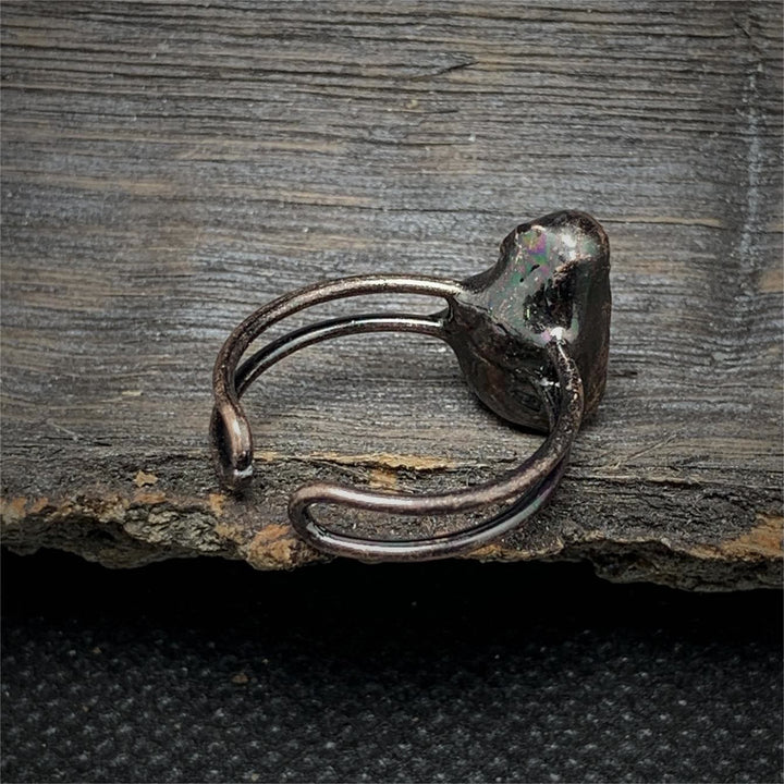 Antiker Silberring auf Holzoberfläche, rustikales Design, handgefertigter Schmuck.