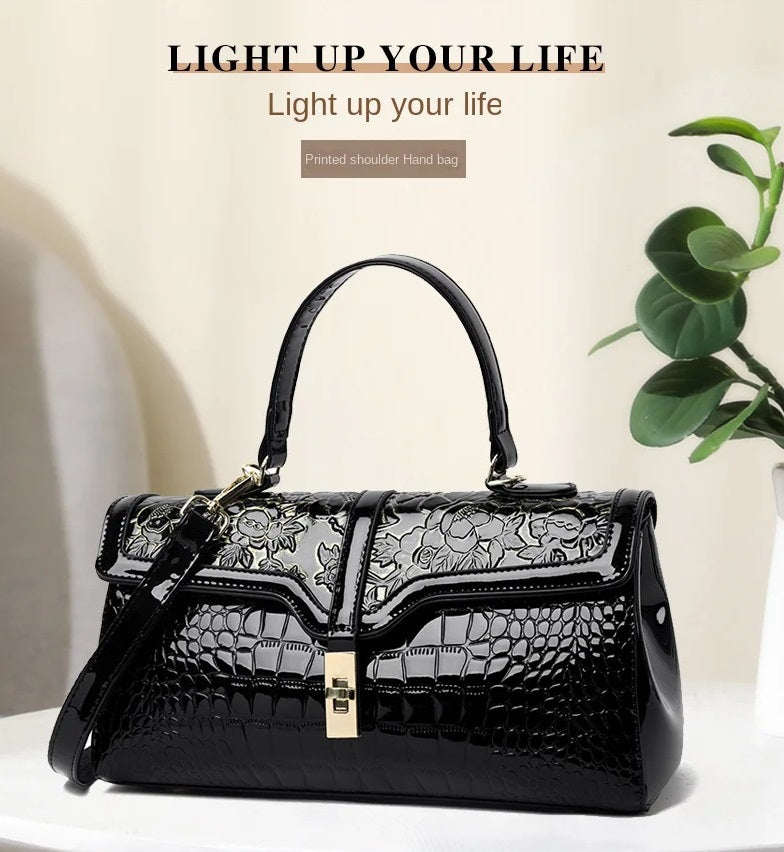 Schwarze Damenhandtasche aus Leder mit Blumenmuster, elegantes Design, modisches Accessoire.