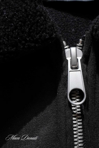 Schwarzer Wollmantel mit silbernem Reißverschluss, Nahaufnahme, Wintermode, Herrenbekleidung.