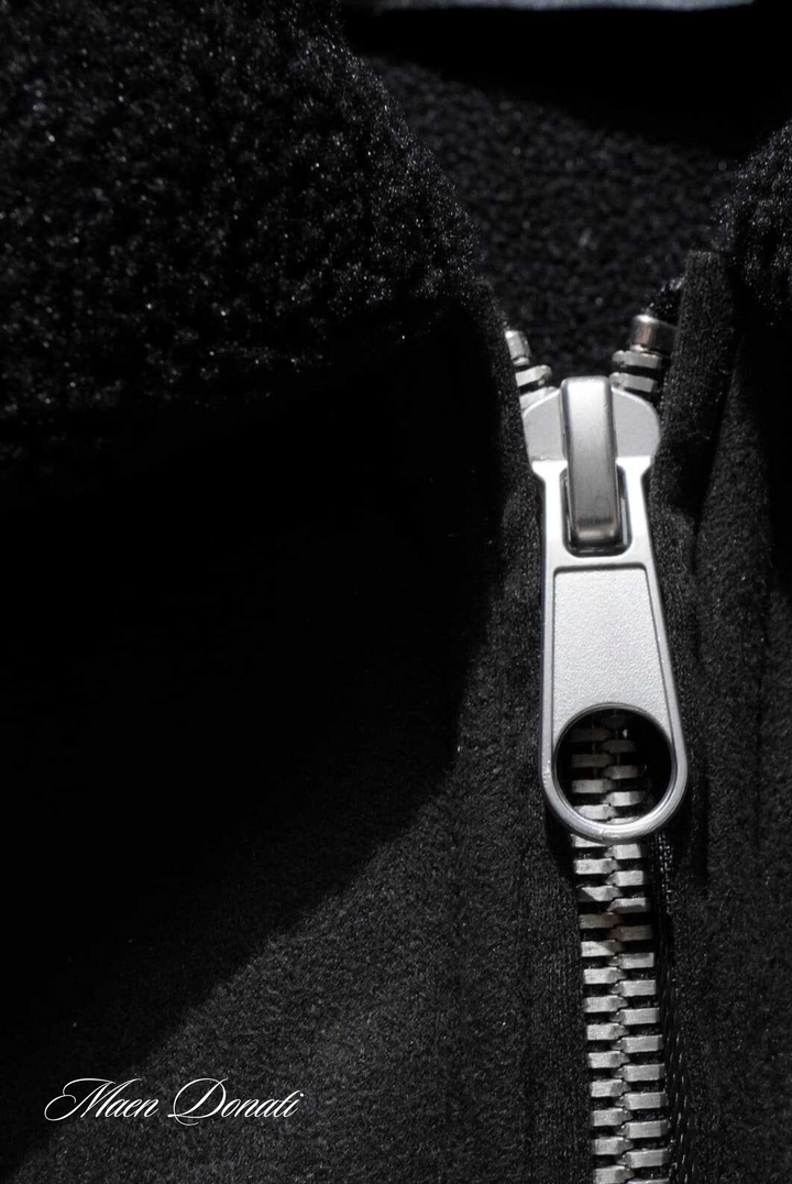 Schwarzer Wollmantel mit silbernem Reißverschluss, Nahaufnahme, Wintermode, Herrenbekleidung.