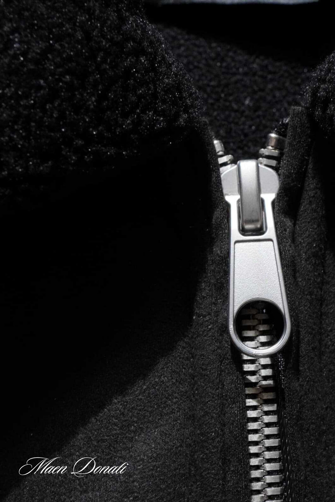Schwarzer Wollmantel mit silbernem Reißverschluss, Nahaufnahme, Wintermode, Herrenbekleidung.