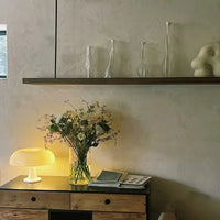 Holzkommode mit Tischlampe, Blumenstrauß und Deko auf Regal, modernes Wohnzimmer-Design.