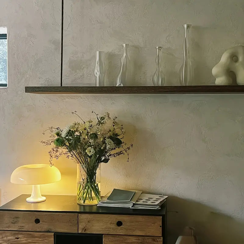 Holzkommode mit Tischlampe, Blumenstrauß und Deko auf Regal, modernes Wohnzimmer-Design.