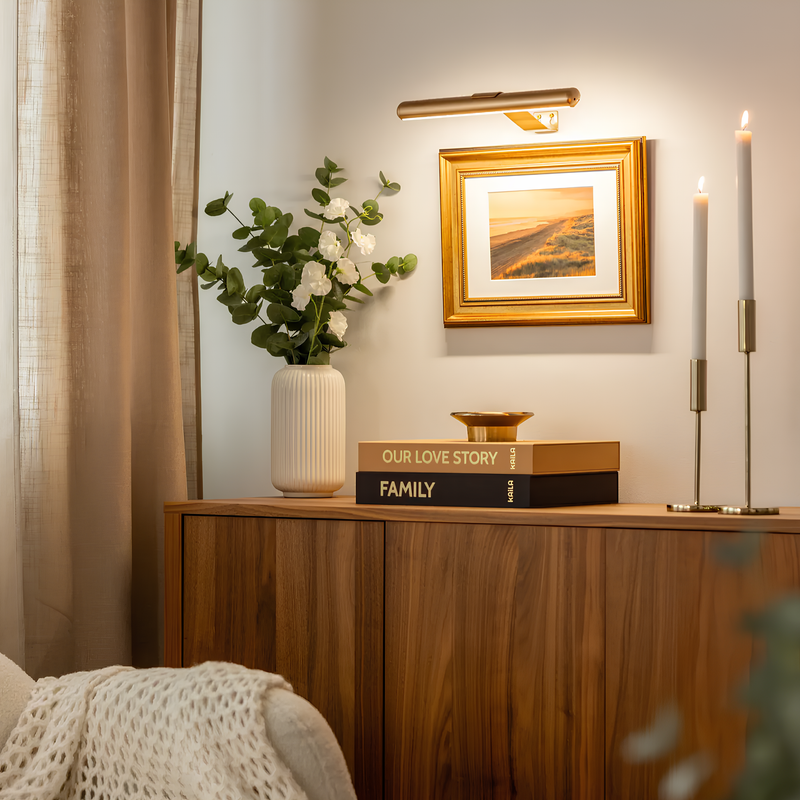 Holzkommode mit Vase, Bücher, Kerzen und gerahmtem Bild, gemütliche Wohnzimmerdekoration.