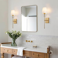 Moderner Badezimmerspiegel mit goldenen Wandleuchten und Holzwaschtisch, elegante Einrichtung.