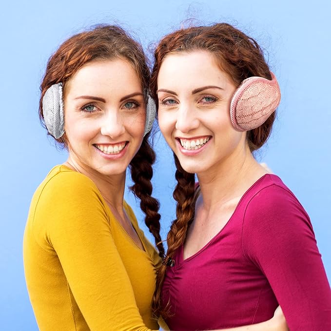 Zwei Frauen mit geflochtenem Haar tragen gestrickte Ohrenschützer vor blauem Hintergrund.