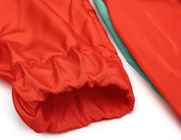 Roter Regenmantelärmel, wasserdicht, Polyester, Outdoor-Bekleidung, Nahaufnahme.