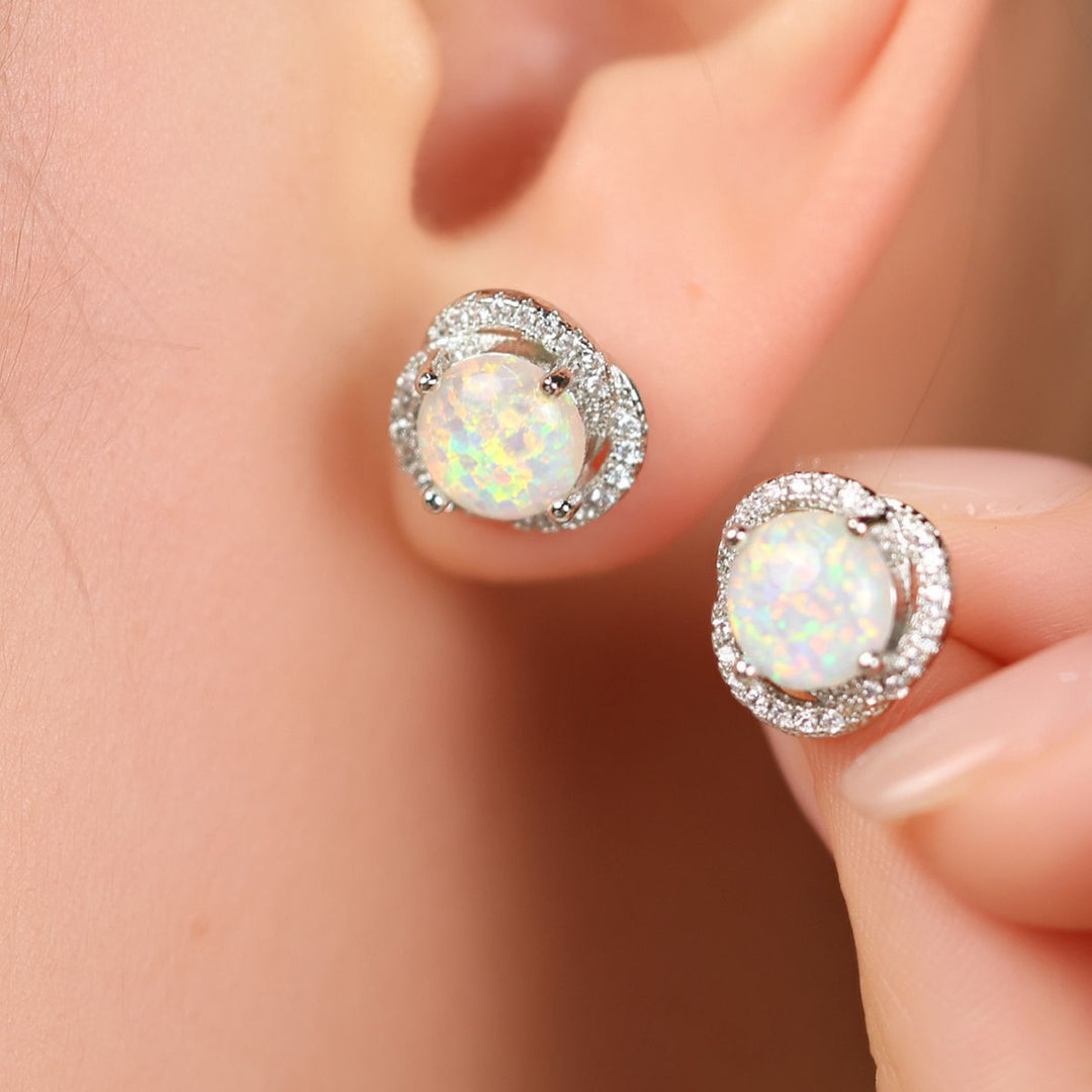 Opal Ohrringe mit Diamanten, rund, Silber, eleganter Schmuck, Nahaufnahme, Damenaccessoire.