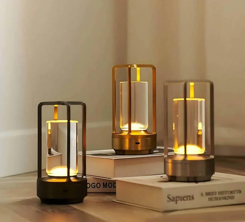 Drei moderne LED-Tischlampen aus Metall auf Büchern, warmes Licht, minimalistisches Design.